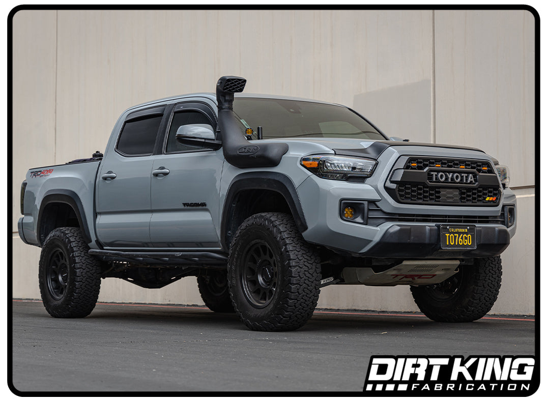 Gray Toyota truck with lifted suspension and 'Dirt King Fabrication' branding on a concrete surface.