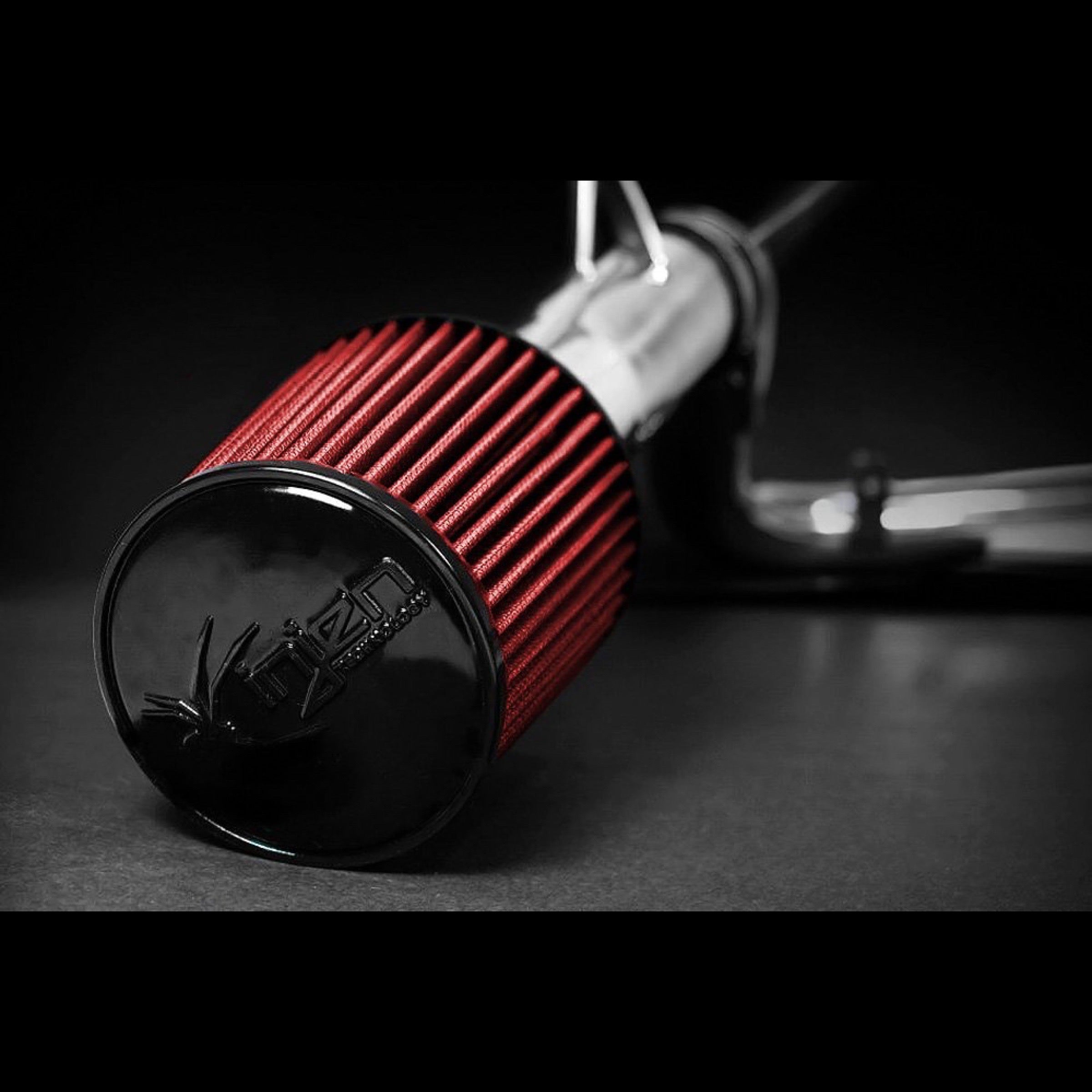 Injen Technology cold air intake with red filter and a black backdrop
